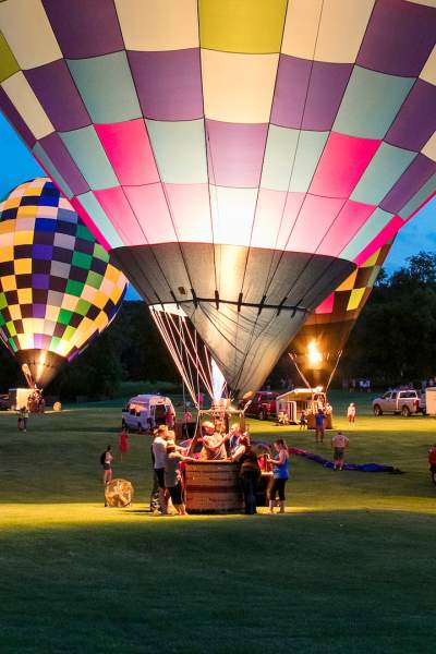 Menschen, die das Great Galena Balloon Race bei Nacht genießen.