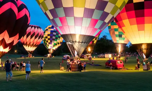 Menschen, die das Great Galena Balloon Race bei Nacht genießen.