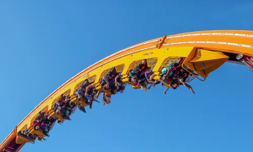 Eine Gruppe von Menschen fährt mit der Achterbahn in der Luft. 