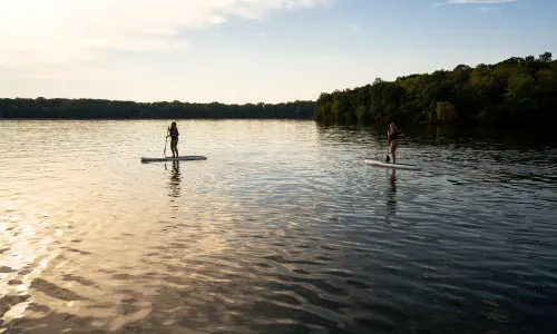 Zwei Personen beim Paddeln auf einem See