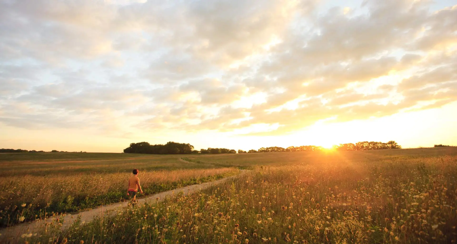 Person beim Wandern durch die Midewin National Tallgrass Prairie bei Sonnenuntergang