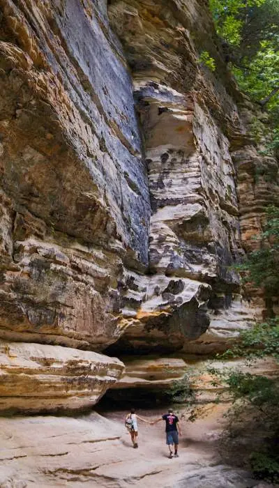 Ein Paar geht neben einem massiven Felsen spazieren