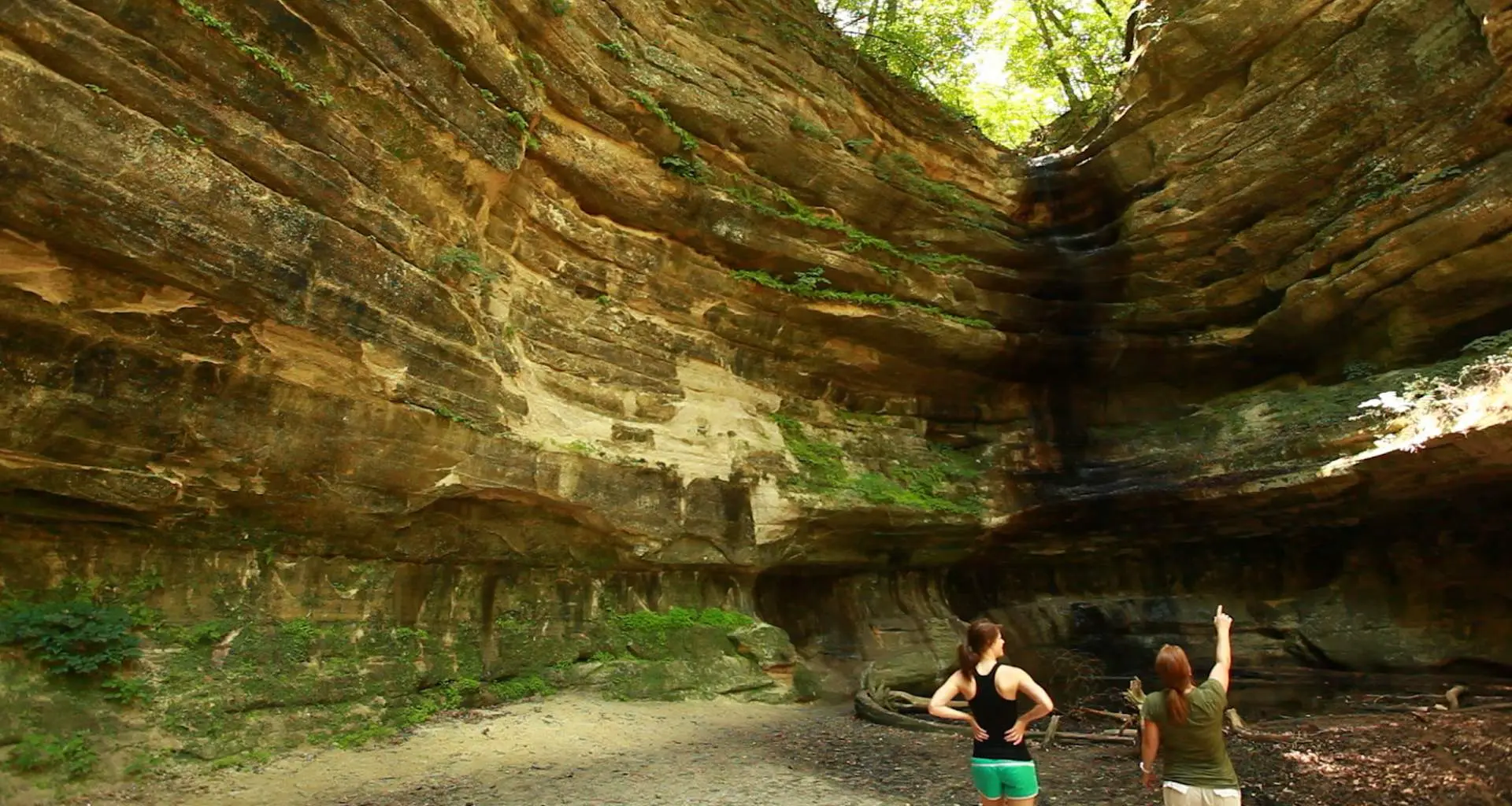 Zwei Menschen blicken auf den großen Felsen, der sie umgibt 