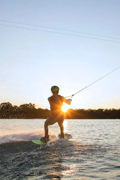 Eine Person beim Wakeboarden im Sonnenuntergang 