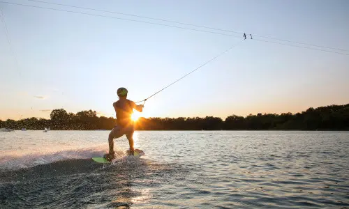 Eine Person beim Wakeboarden im Sonnenuntergang