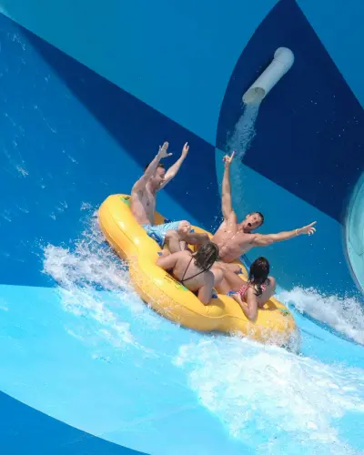 Eine Gruppe von vier Personen in einem aufblasbaren Floß auf einer Wasserrutsche