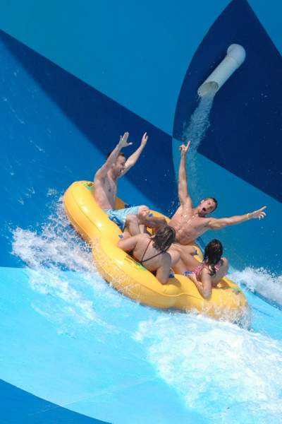 Eine Gruppe von vier Personen in einem aufblasbaren Floß auf einer Wasserrutsche