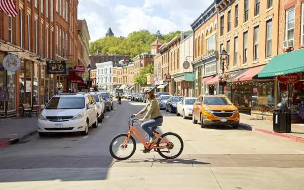 Ein Radfahrer auf einem E-Bike überquert die Hauptstraße einer Kleinstadt