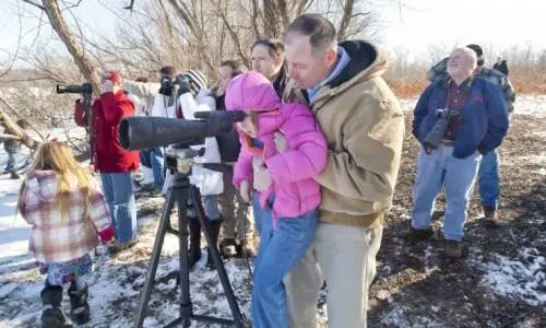 Menschen, die durch ein großes Kameraobjektiv schauen
