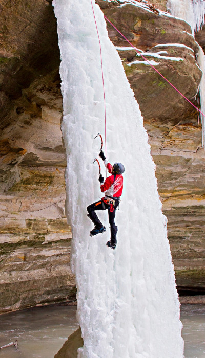 Person klettert auf Eiswasserfall