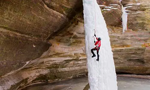 Person klettert auf Eiswasserfall