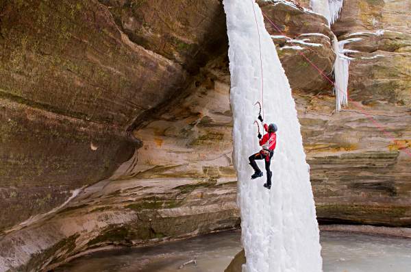 Person klettert auf Eiswasserfall