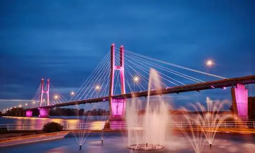 Eine beleuchtete Brücke mit Wasserfontänen