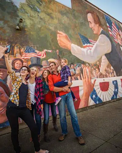 Familie macht ein Selfie vor einer Wandmalerei in Ottawa