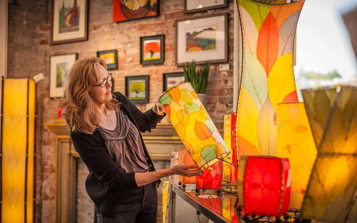 Eine Frau kauft in der Curtis Frame Back Alley Gallery in Libertyville Laternen ein.